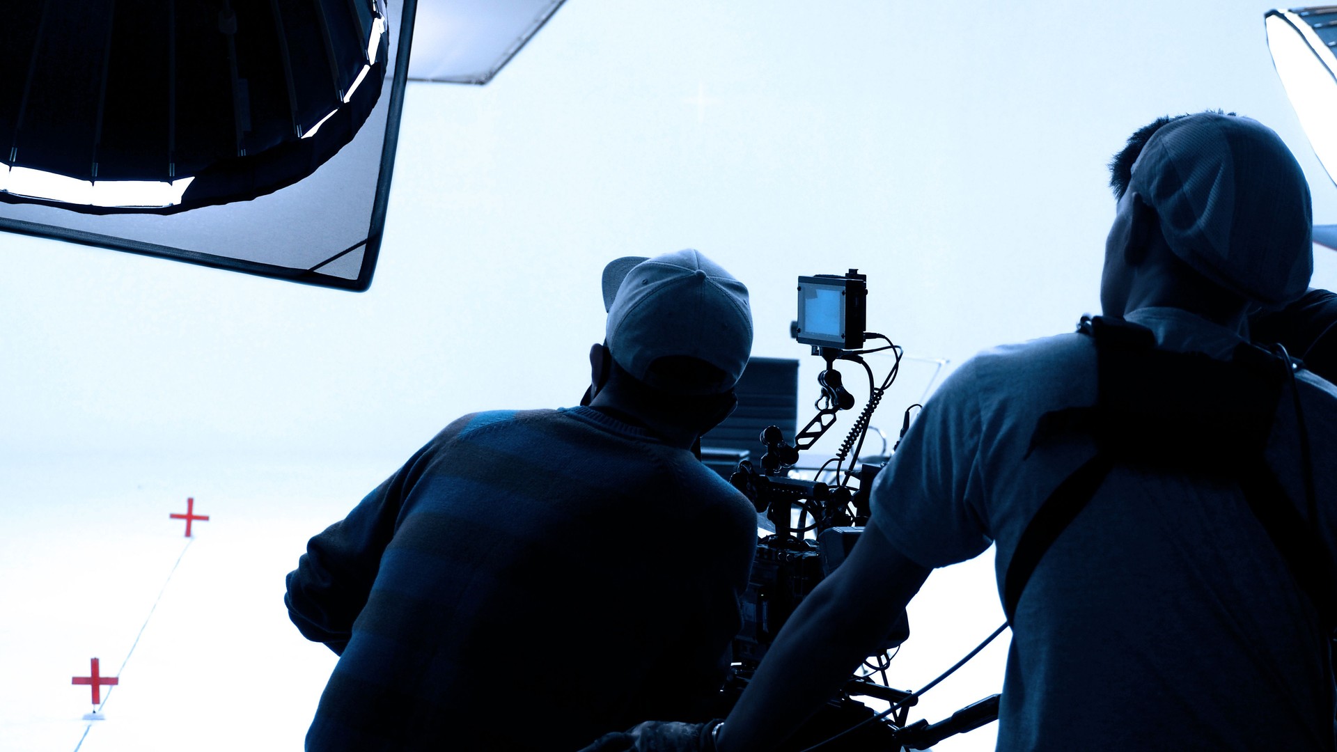 Video production behind the scenes. Making of TV commercial movie that film crew team lightman and cameraman working together with film director in studio. film production concept. Silhouette style.